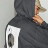 A person wearing a hat and a hoodie.