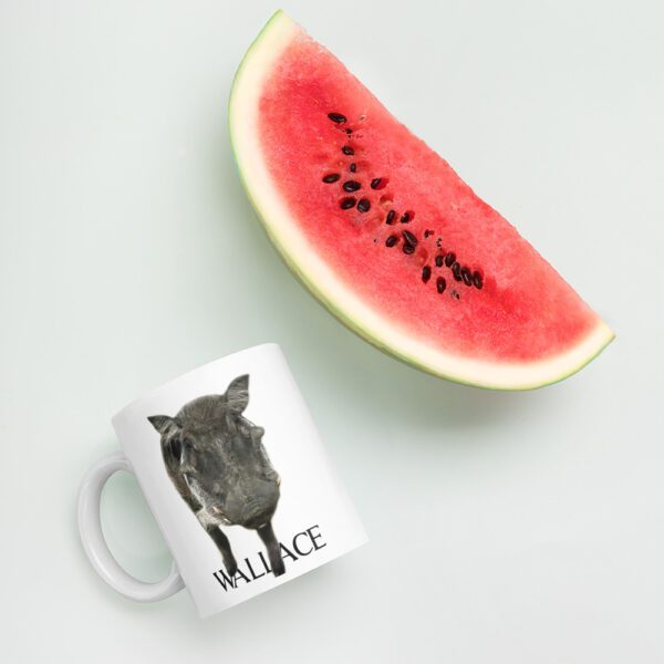 A watermelon and a mug with the image of a cow.