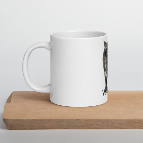 A white coffee mug sitting on top of a wooden table.
